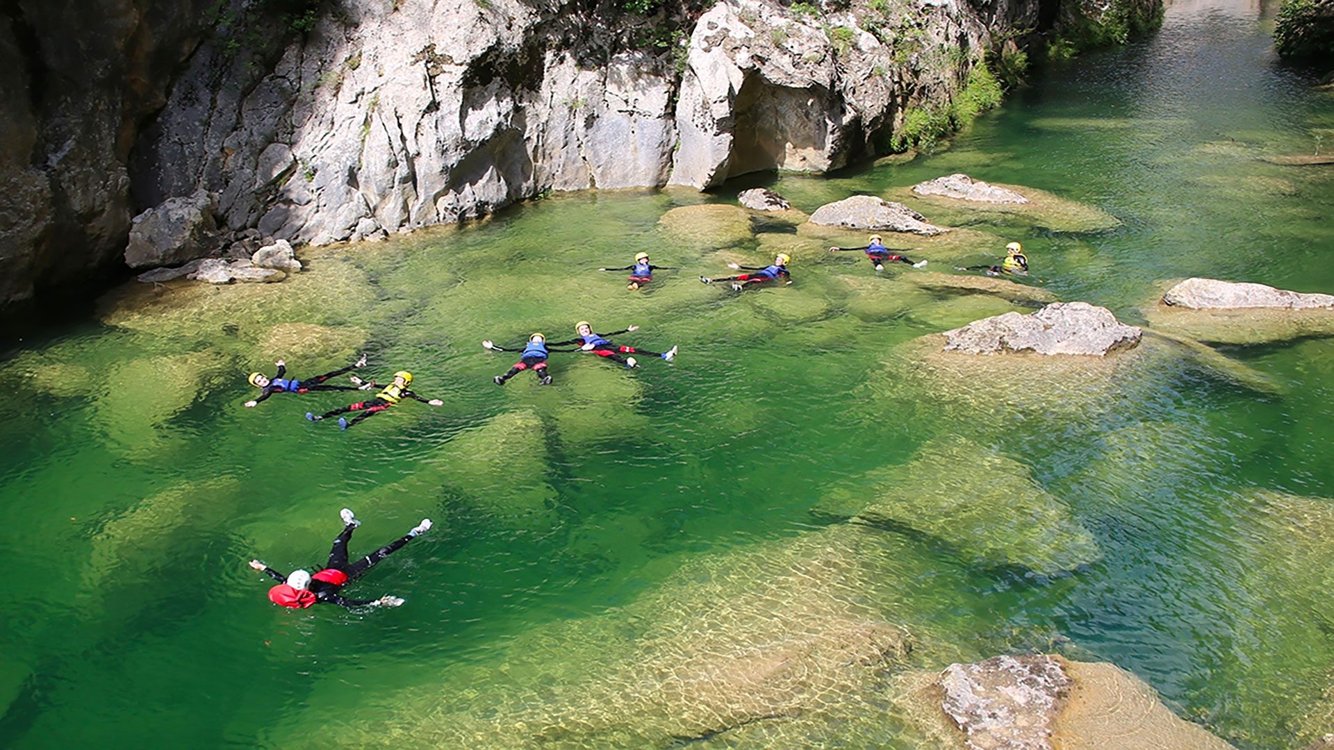 Canyoners swimming in a river during canyoning
