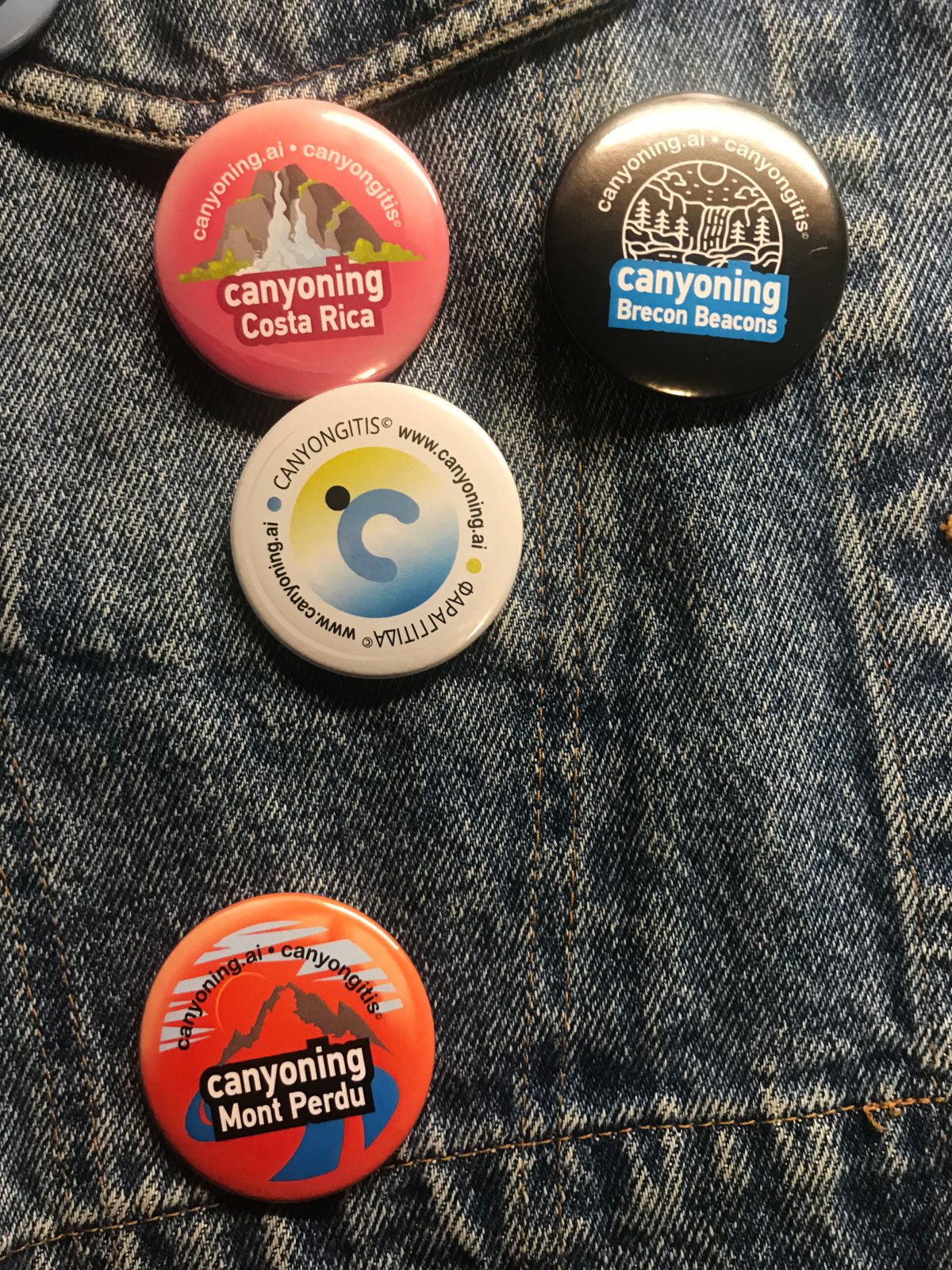 Canyoning badges pinned on a jean jacket front